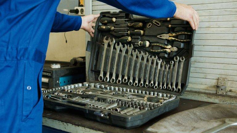 Un homme ouvrant sa boîte à outils pour assurer un bon service aux chaînes de fabrication